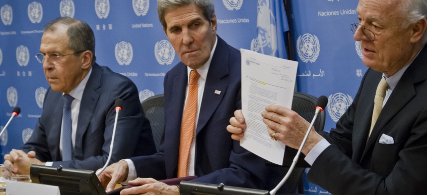 U.N. Special Envoy for Syria Staffan de Mistura, shows a copy of a Security Council resolution concerning Syria, during a press conference with Russian Foreign Minister Sergey Lavrov and U.S. Secretary of State John Kerry.