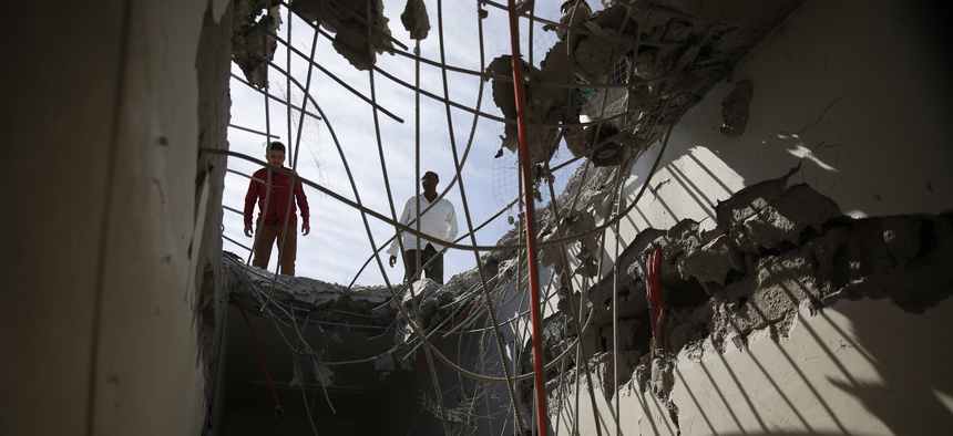 Men inspect a building damaged by a Saudi-led airstrike in Sanaa, Yemen, Tuesday, Jan. 5, 2016.
