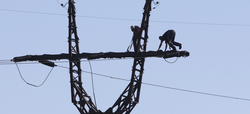 Workers repair an electricity power line damaged during shelling near a power station outside the city of Slovyansk, Donetsk Region, eastern Ukraine Thursday, July 10, 2014.