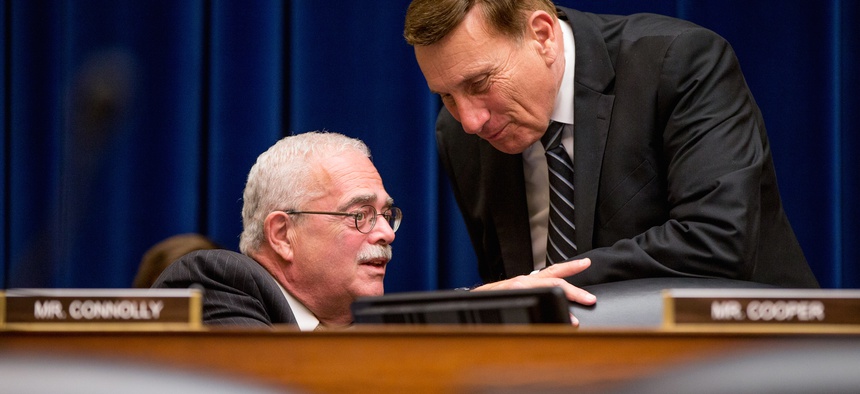 Rep. Gerald Connolly, D-Va., left, speaks with Rep. John Mica, R-Fla., right, on Capitol Hill in Washington, Wednesday, June 17, 2015, during the House Oversight and Government Reform Committee hearing.