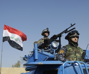 In this Nov. 22, 2011 file photo, the Iraqi flag waves while federal police parade in Baghdad. 