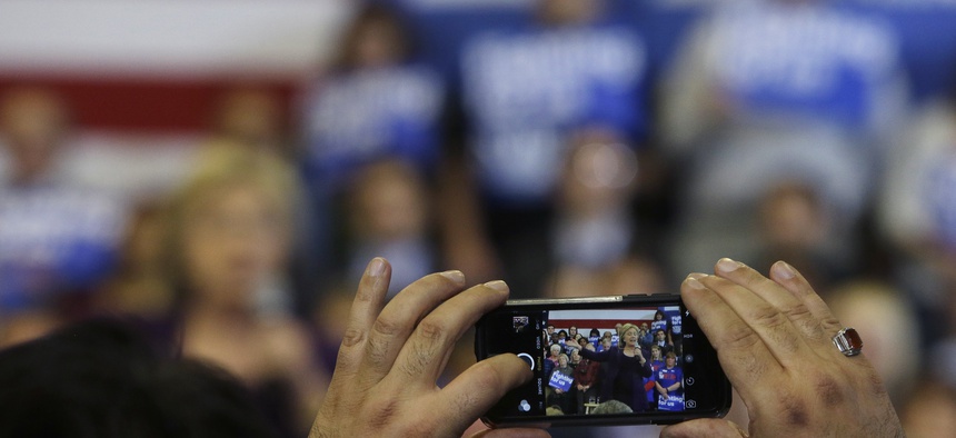 A potential voter takes a photo as Democratic presidential candidate Hillary Clinton speaks at a campaign event, Tuesday, Feb. 2, 2016, in Nashua, N.H.