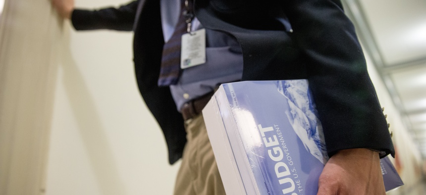 A Capitol Hill staff member holds a copy of President Barack Obama's fiscal 2017 federal budget after it is delivered to the House Budget Committee Room on Capitol Hill in Washington, Tuesday, Feb. 9, 2016.