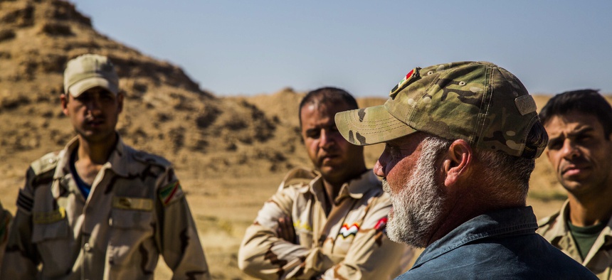Iraqi Soldiers listen to a civilian contractor attached to Task Force Al Asad, talk about counter-improvised explosive device aboard Al Asad Air Base, Iraq, April 2, 2015.
