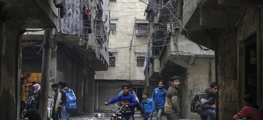 In this Thursday, Feb. 11, 2016 photo, school boys play in a street in Aleppo, Syria.