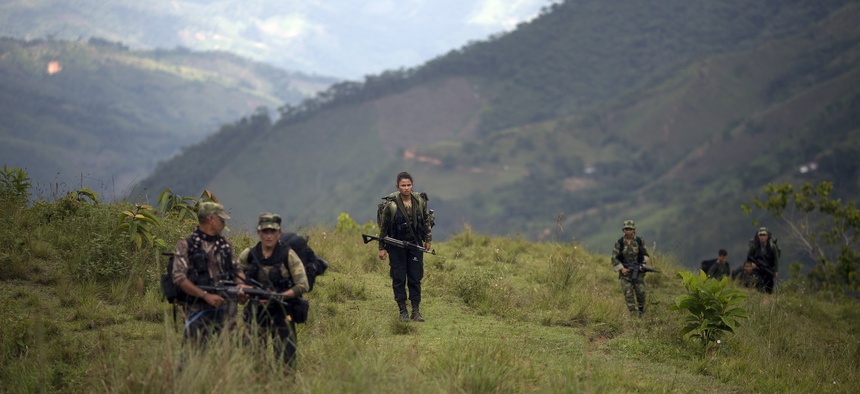 In this Jan. 3, 2016 photo, members of the 36th Front of the Revolutionary Armed Forces of Colombia or FARC, trek to a new camp in Antioquia state, in the northwest Andes of Colombia.