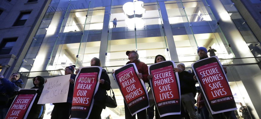 Protesters carry placards outside an Apple store in Boston on Feb. 23, 2016.