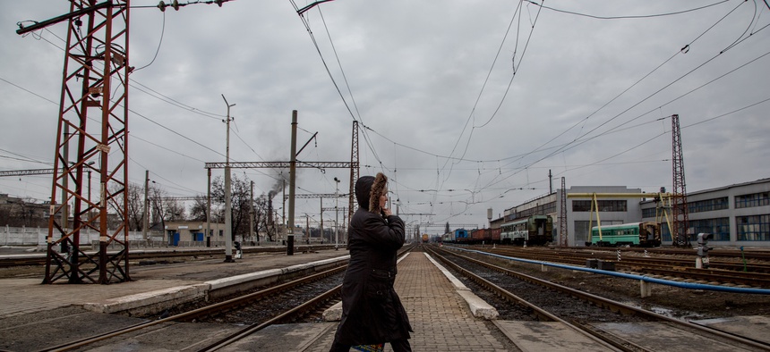 In this photo taken on Friday, Feb. 5, 2016, a local woman walks along a rail-road crossing in Debaltseve, eastern Ukraine. Money from Russia helps to rebuild the eastern Ukrainian town of Debaltseve, a strategic rail hub that rebels pounded recently.