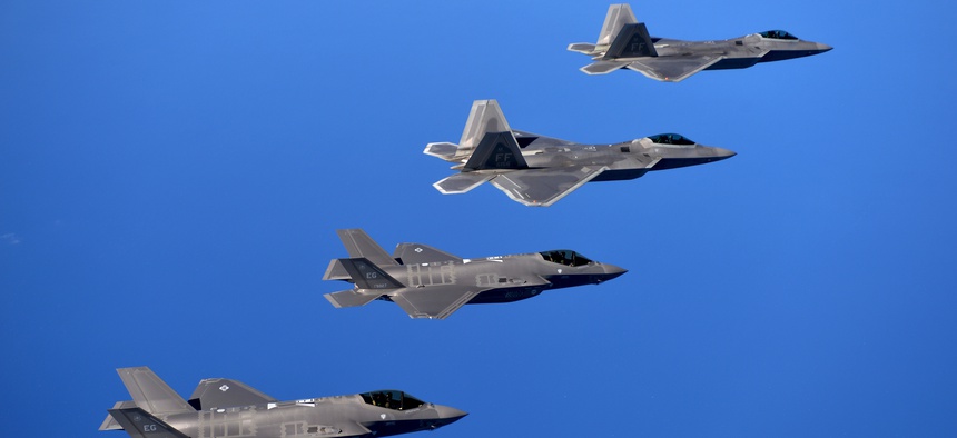 F-22 Raptors from the 94th Fighter Squadron and F-35A Lightning IIs fly in formation after completing a training mission.