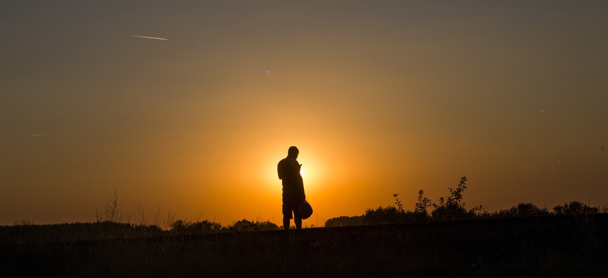 In this Tuesday, Sept. 1, 2015, photo, a Syrian refugee checks his phone after he cross the borders from Serbia to Hungary near the town of Röszke, Hungary.