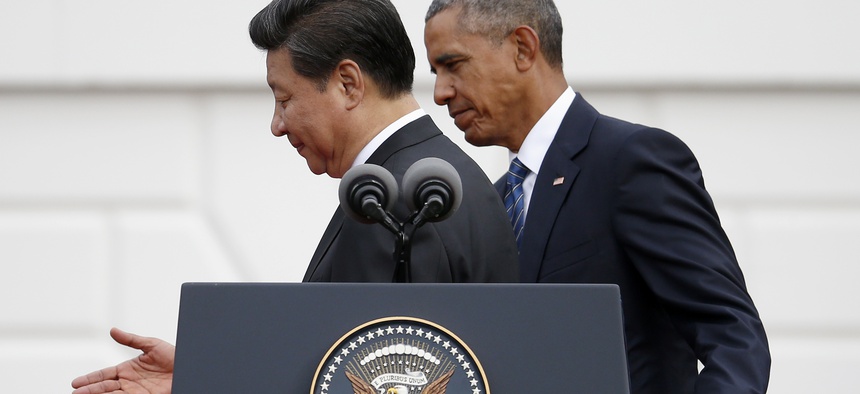 President Barack Obama guides Chinese President Xi Jinping off the podium at the conclusion of the official state arrival ceremony for the Chinese president, Friday, Sept. 25, 2015, on the South Lawn of the White House in Washington.