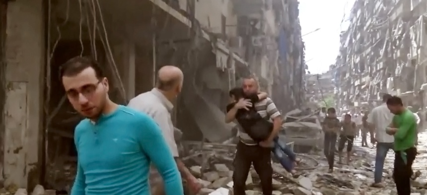 A man carries a child after airstrikes hit Aleppo, Syria, Apr. 28, 2016.