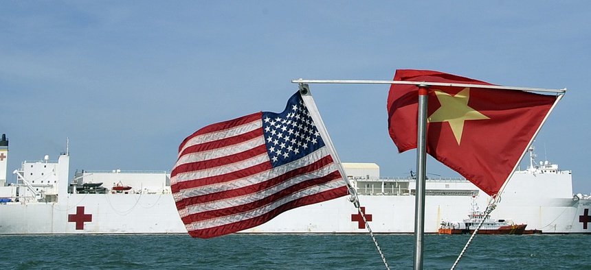 U.S. and Vietnamese flags fly in unison as the Military Sealift Command hospital ship USNS Mercy (T-AH 19) sits on station in the Gulf of Tonkin, July 13, 2012.