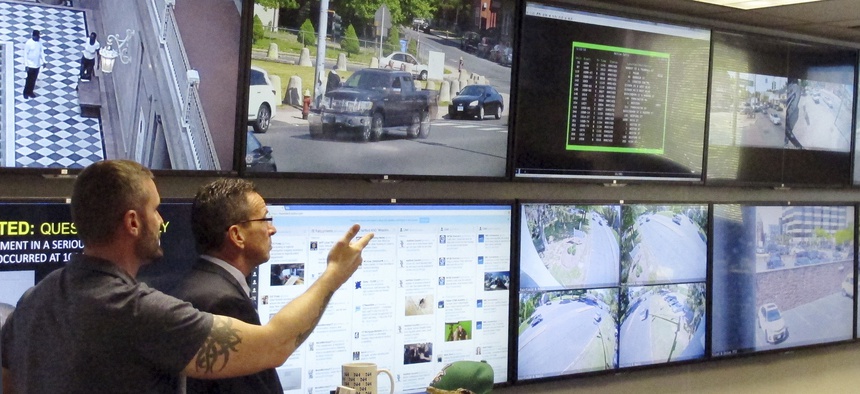 In this Friday, May 20, 2016 photo, Hartford police Sgt. Johnmichael O'Hare, left, shows Connecticut Gov. Dannel P. Malloy the police department's Real-Time Crime and Data Intelligence Center in Hartford, Conn.