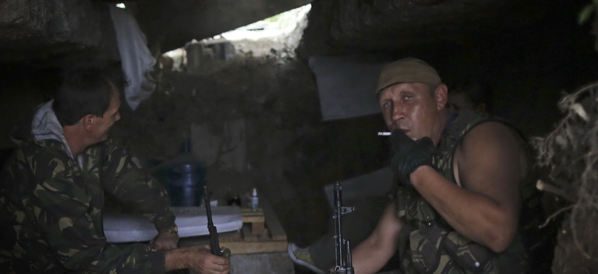 Pro-Russian rebels rest inside a shelter at their position outside Donetsk, eastern Ukraine, Friday, Aug. 22, 2014. Tensions between Russia and Ukraine escalated sharply on Friday as Moscow sent more than 130 trucks rolling across the border.