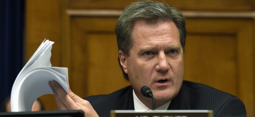 House Oversight and Government Reform Committee member Rep. Mike Turner, R-Ohio holds up a security form as he asks questions during the committee's hearing on recent cyber attacks at OPM, Wednesday, June 24, 2015, on Capitol Hill.