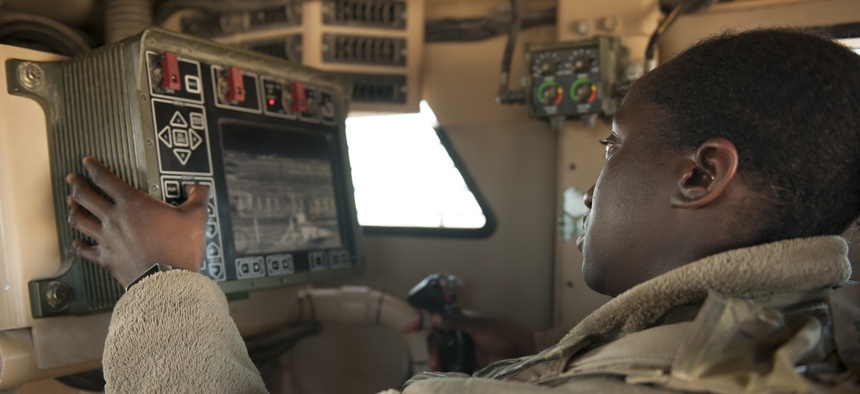 Senior Airman Amanda Nolan, 451st Expeditionary Support Squadron Security Forces Flight, scans a sector on a common remote operating weapons station from vehicle at Delta-1 Post on Kandahar Airfield, Afghanistan, January 20, 2016.