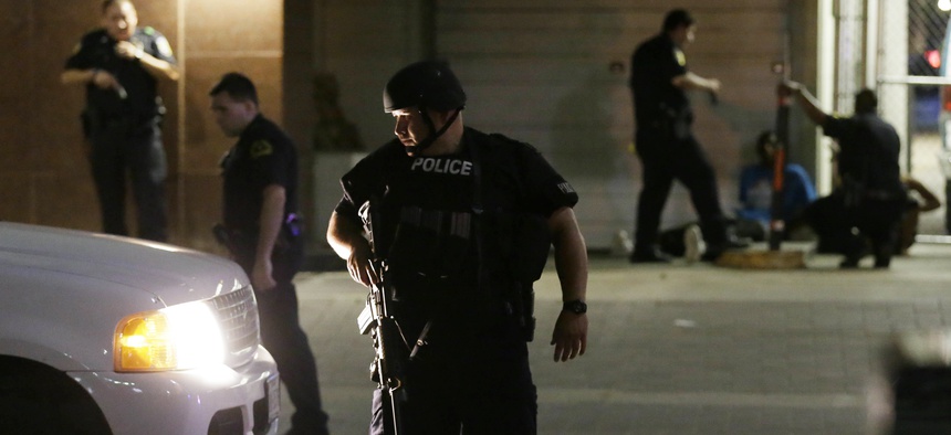 Dallas police detain a driver after several police officers were shot in downtown Dallas on July 7, 2016.