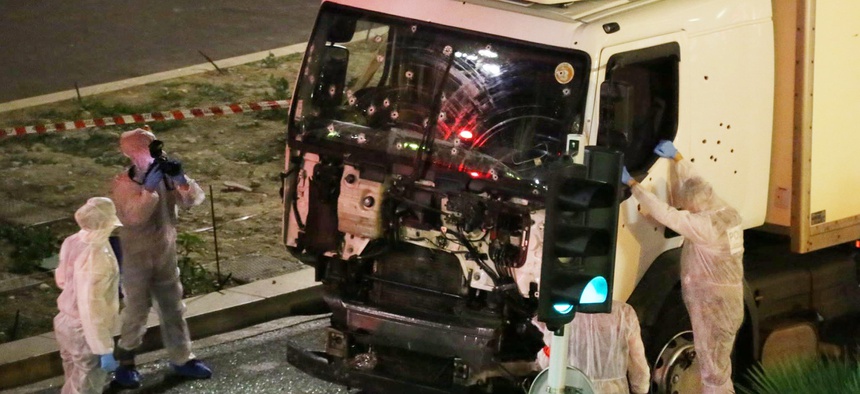 Authorities investigate a truck after it plowed through Bastille Day revelers in the French resort city of Nice, France, Thursday, July 14, 2016.