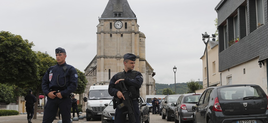 Police officers prevent the access to the church where an hostage taking left a priest dead the day before in Saint-Etienne-du-Rouvray, Normandy, France, Wednesday, July 27, 2016.