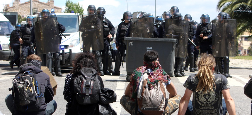 Protestors sit in front of riot police, after a demonstration in Marseille, southern France, Thursday, May 12, 2016.