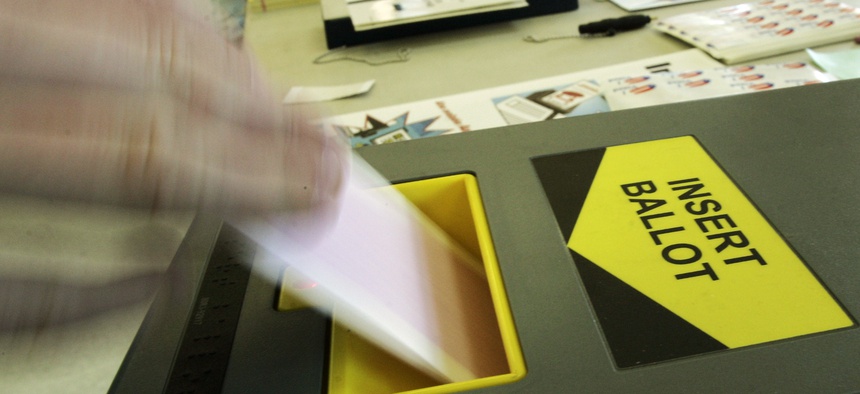 A voter feeds a ballot into an Inka-Vote machine at a polling place at Malibu Bluffs Park in Malibu, Calif., Tuesday, Feb. 5, 2008.