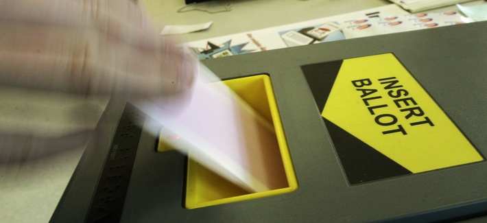 A voter feeds a ballot into an Inka-Vote machine at a polling place at Malibu Bluffs Park in Malibu, Calif., Tuesday, Feb. 5, 2008. 