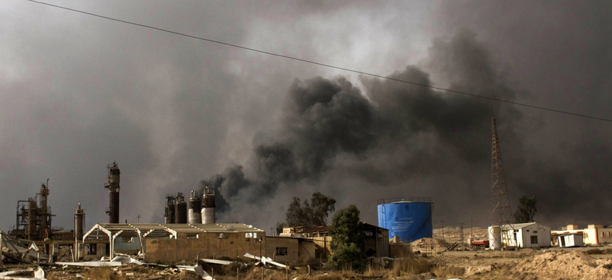 Oil wells on the edge of the Iraqi town Qaraya burned days after the key town south of was retaken from the Islamic State