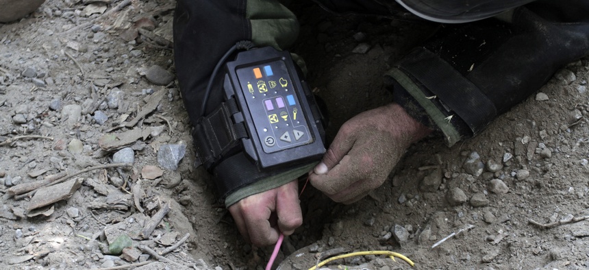 An Afghan soldier defuses IEDs at a training exercise in Jalalabad, east of Kabul, Afghanistan, Aug. 27, 2013.