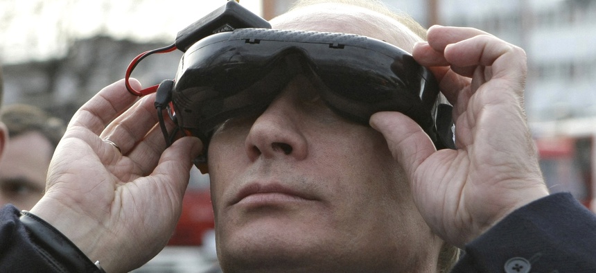 Russian Prime Minister Vladimir Putin tests goggles with an electronic connection that allows him to see the view from an unmanned drone aircraft, during an exhibition of equipment displayed at Russia's Civil Defense Academy in Moscow's Khimki surburbs.
