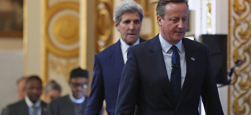 British Prime Minister Cameron, right, followed by U.S. Secretary of State John Kerry arrive to open London Anti-Corruption Summit on May 12, 2016, in London.