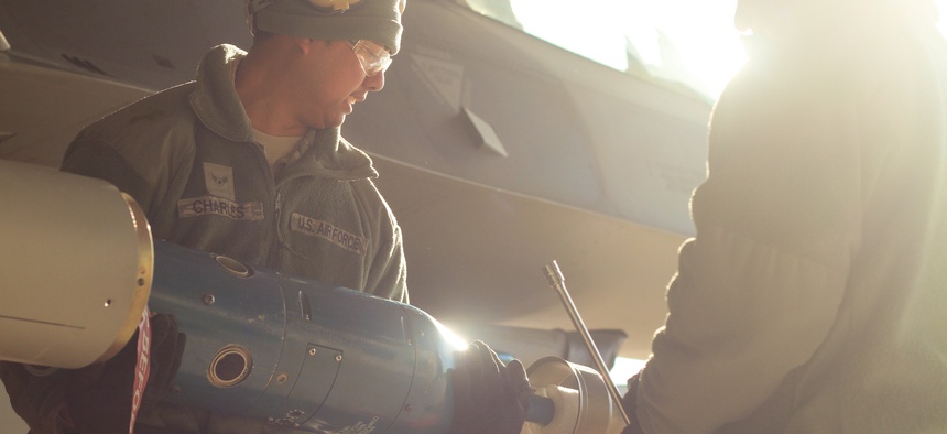 U.S. Airmen unload a GBU-12 Paveway II on an F-16C Fighting Falcon during day one of the annual load crew competition on Jan. 9 at Atlantic City Air National Guard Base, N.J.