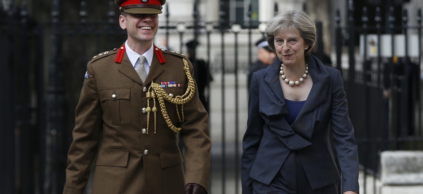 Britain's Prime Minister Theresa May walks with Col. John Clark a Military Advisor at 10 Downing Street in London, Sept. 22, 2016.