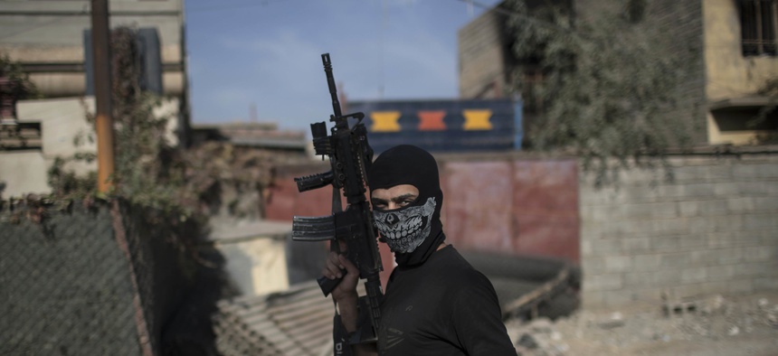 A Iraqi special forces fighter walks with his rifle during flighting with Islamic State militants in eastern Mosul, Iraq, Sunday, Nov. 13, 2016.