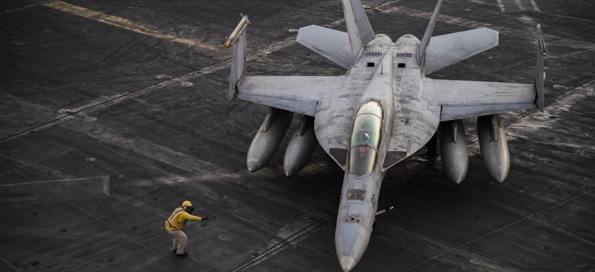 An F/A-18F Super Hornet deployed as part of Operation Inherent Resolve taxis across the flight deck the aircraft carrier USS Dwight D. Eisenhower.