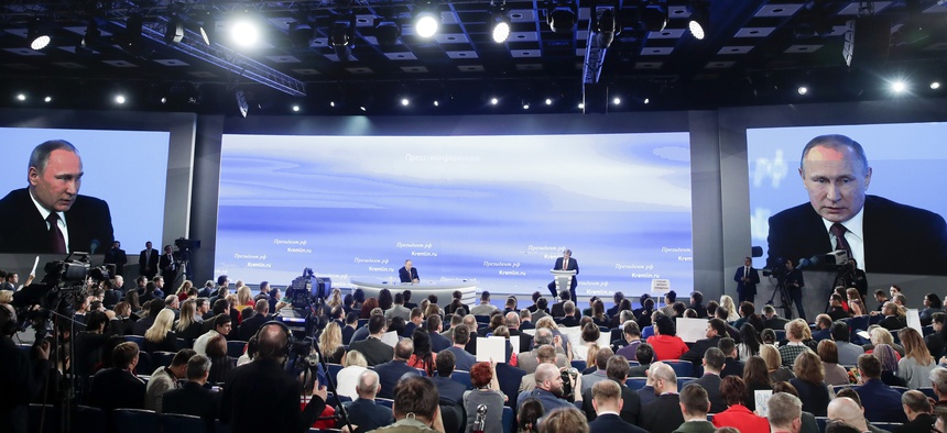Russian President Vladimir Putin, center back, speaks during his annual news conference in Moscow, Russia, Friday, Dec. 23, 2016.