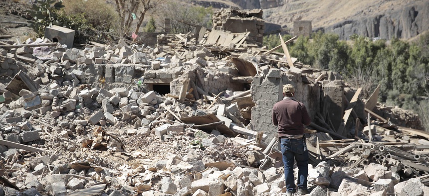 A man walks amid the rubble of a house destroyed by a Saudi-led airstrike on the outskirts of Sanaa, Yemen, Thursday, Feb. 2, 2017.