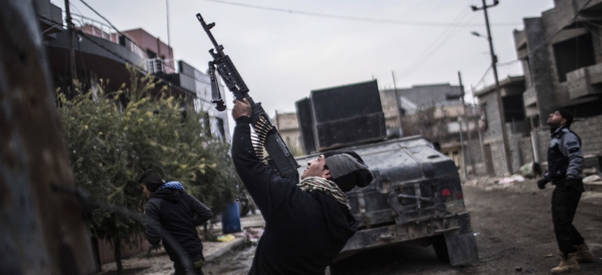 A member of the Iraqi Special Forces shoots his machine gun at an Islamic State militant drone n the al-Barid district in Mosul, Iraq on Dec. 18, 2016.