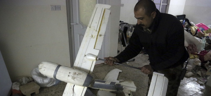 In this Friday, Jan. 27, 2017 photo, an Iraqi officer inspects drones belonging to Islamic State militants in Mosul, Iraq.