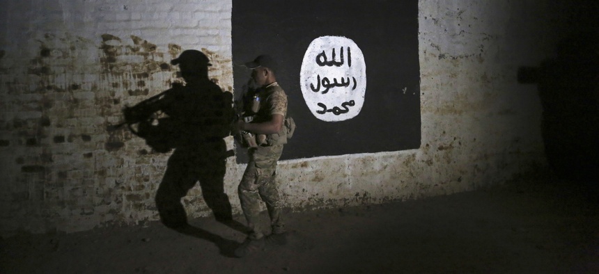 An Iraqi soldier inspects a recently-discovered train tunnel, adorned with an Islamic State group flag, that belonged to the former Baghdad to Mosul line, that was turned it to a training camp for IS fighters, in western Mosul, Iraq, March 1, 2017.