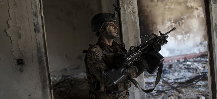 A Iraqi special forces soldier walks in a burned house near the front line during fighting against Islamic State militants in west Mosul, Iraq, Friday, March 17, 2017.