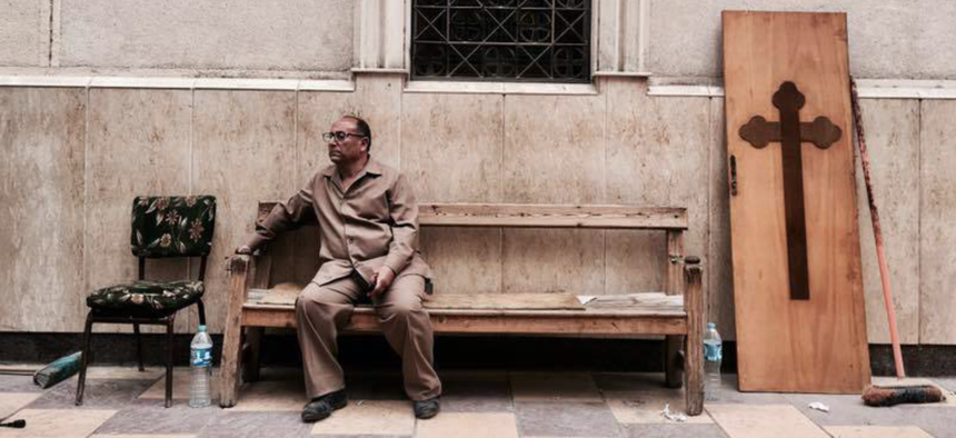 A man sits on a bench outside a church after a bomb attack in the Nile Delta town of Tanta, Egypt, Sunday, April 9, 2017.