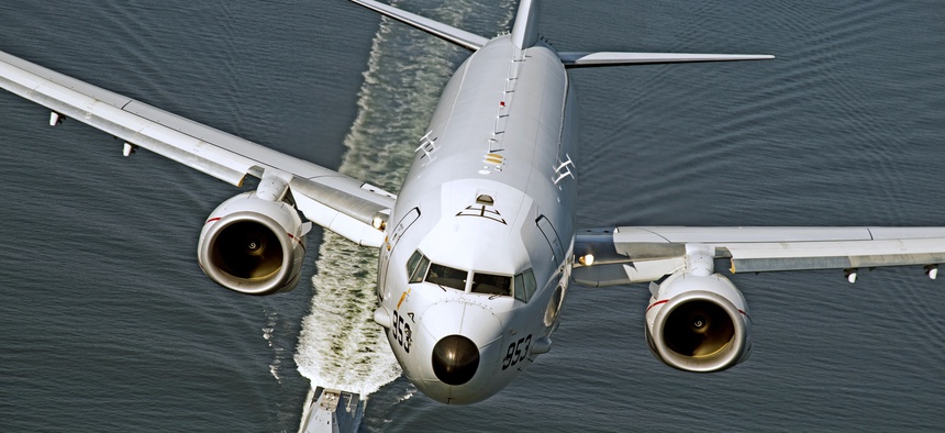 A P-8A Poseidon overflies the U.S. Navy's DDG 1000 destroyer in October 2016. The subhunting plane has been approved for export to New Zealand.