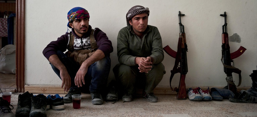 In this Nov. 1, 2014 photo, Kurdish fighters have a short tea break from fighting in Kobani, Syria.