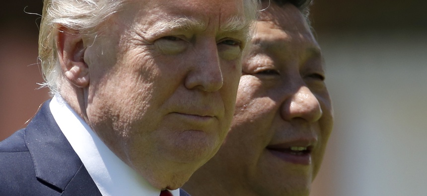 In this April 7, 2017, file photo, U.S. President Donald Trump and Chinese President Xi Jinping walk together at Mar-a-Lago in Palm Beach, Fla.