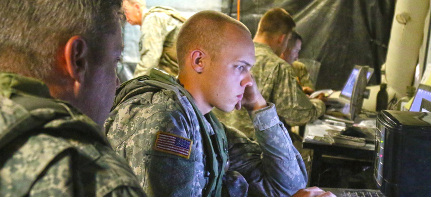 Spc. Clayton McInnis, a human intelligence analyst, with 1st Battalion, 155th Infantry Regiment, Mississippi Army National Guard, reviews reports in the unit’s tactical operations center at the National Training Center.