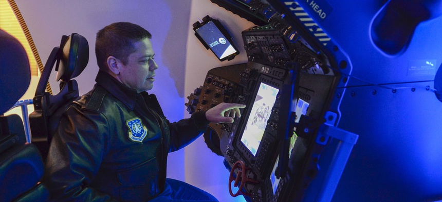 An astronaut from Air Force Space Command, pilots the Boeing Starliner simulator at the 33rd Space Symposium in Colorado Springs, Colo., April 6, 2017.