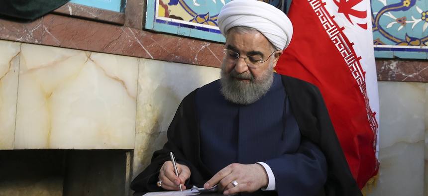 In this photo released by official website of the office of the Iranian Presidency, President Hassan Rouhani fills in his ballot while voting for the presidential and municipal councils election at a polling station in Tehran, Iran, Friday, May 19, 2017.