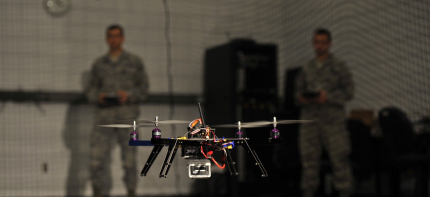U.S. Air Force Capt. Wilfred Noel, deputy chief of the Air Force Research Lab, left, and 1st Lt. Jason Rathje, an advanced weapon design engineer with Air Force Research Lab weapons dynamics and control science branch, right, pilot quadrotor vehicles.