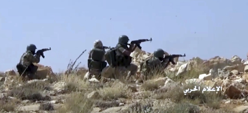 This frame grab from video released on Saturday, July 22, 2017 and provided by the government-controlled Syrian Central Military Media, shows Hezbollah fighters taking position during clashes with al-Qaida-linked militants in an area on the Lebanon-Syria
